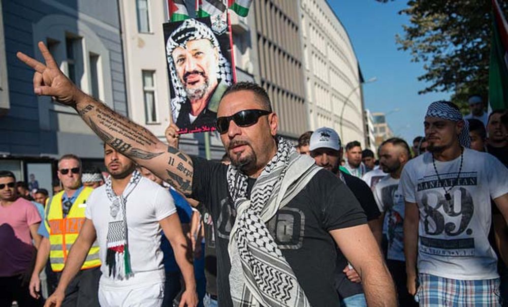 Antisemitische Demonstration in Berlin am 17. Juli 2014: Der Teilnehmer mit Palästinensertuch hat „88“ am rechten Unterarm eintätowiert - ein Nazi-Zahlencode für den Hitlergruß, darüber ein Lob auf die Palästinenser, die sich „als einzige … gegen den Zionisten wehren“ 