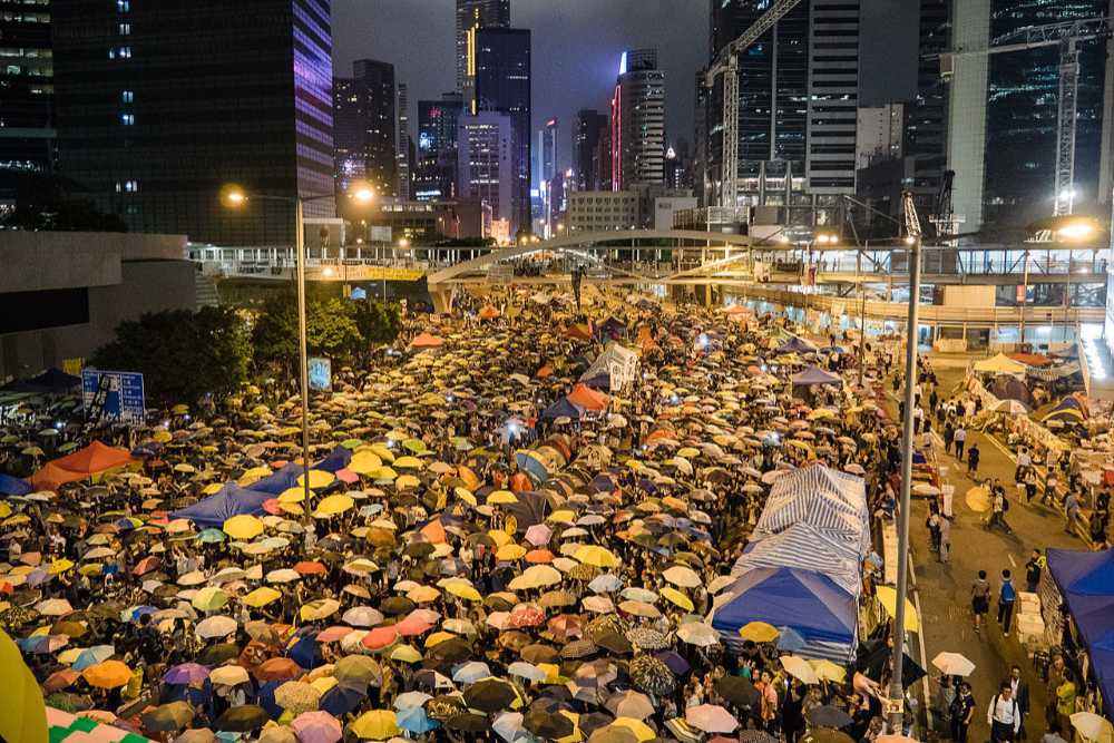 Demonstrierende der Demokratiebewegung in Hongkong mit aufgespannten Regenschirmen.