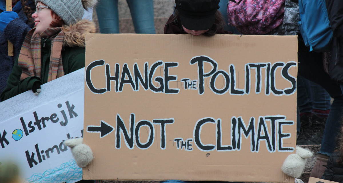 Schild bei Klimaprotest mit der Aufschrift „Change the Politics, not the Climate“.