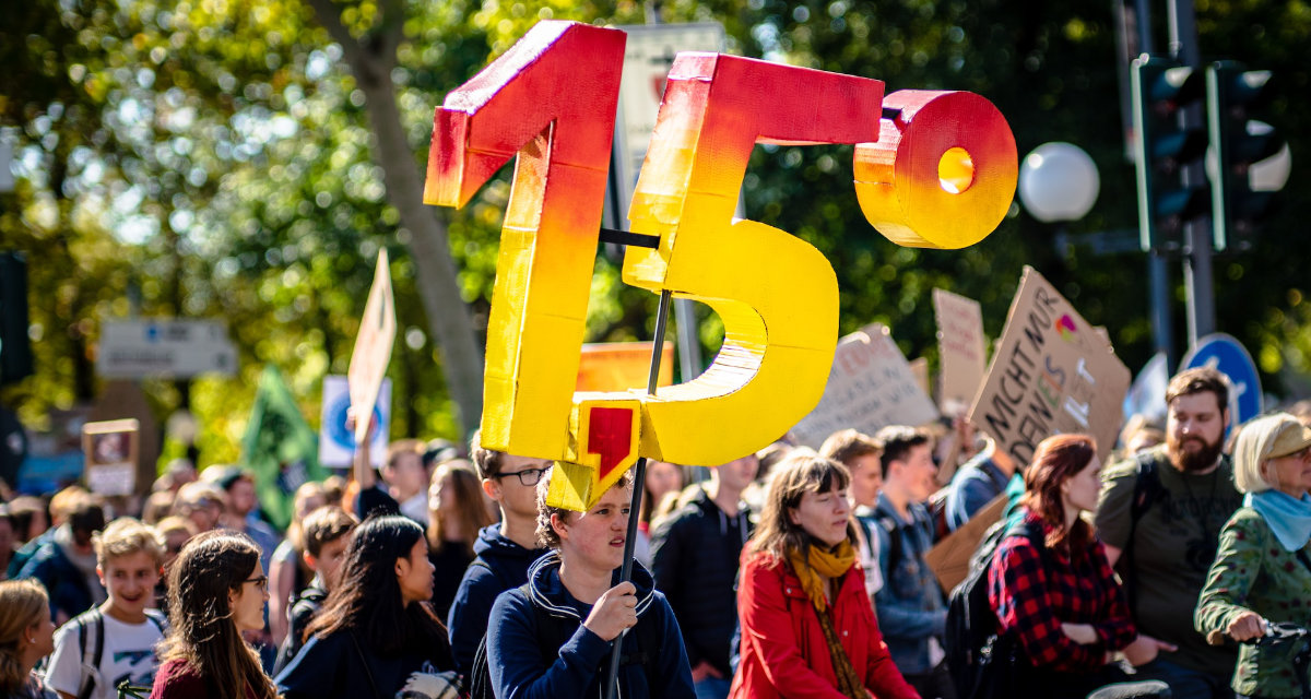 Klimademonstrierende mit 1,5 Grad-Schild in Bonn. Foto: unsplash | Mika Baumeister