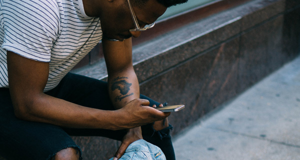 Mann schaut auf sein Smartphone. Foto: Derick Anies / Unsplash.