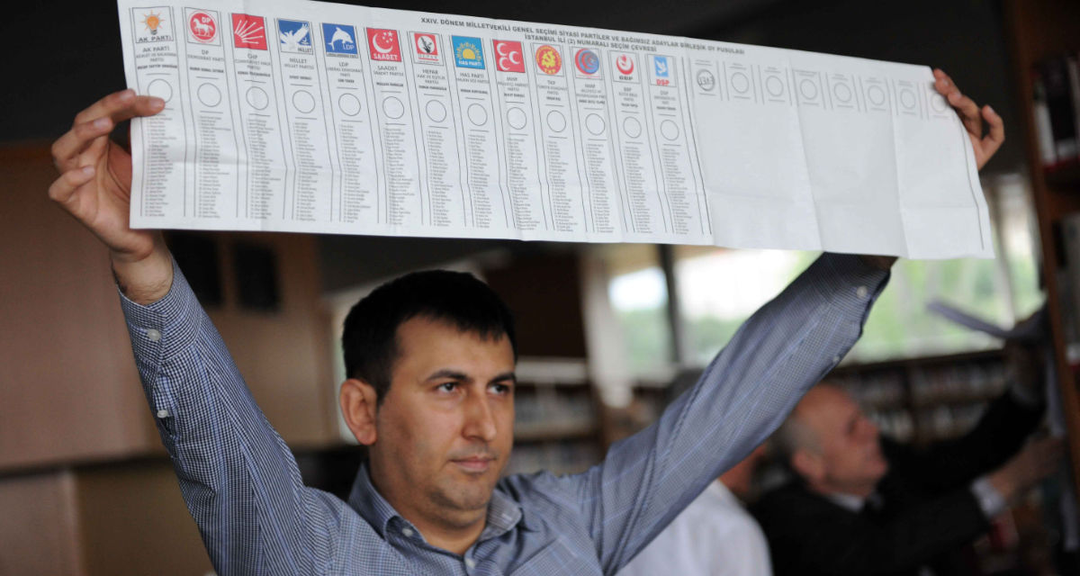 Ein Mann hält einen Stimmzettel in die Höhe, auf dem die türkischen Parteien verzeichnet sind, die 2011 bei den Parlamentswahlen angetreten sind. © picture alliance/Photoshot Ein Mann hält einen Stimmzettel in die Höhe, auf dem die türkischen Parteien verzeichnet sind, die 2011 bei den Parlamentswahlen angetreten sind.